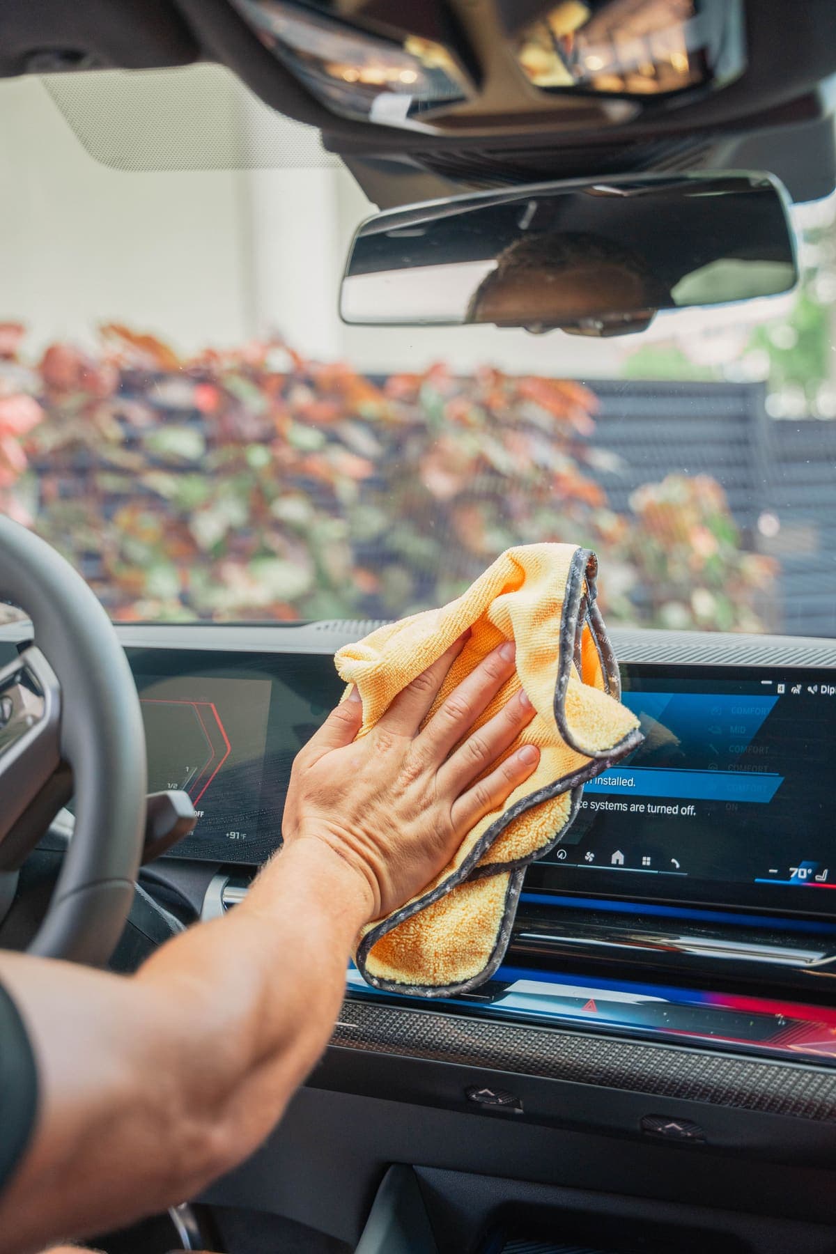 Wiping down a dashboard display with a microfiber towel